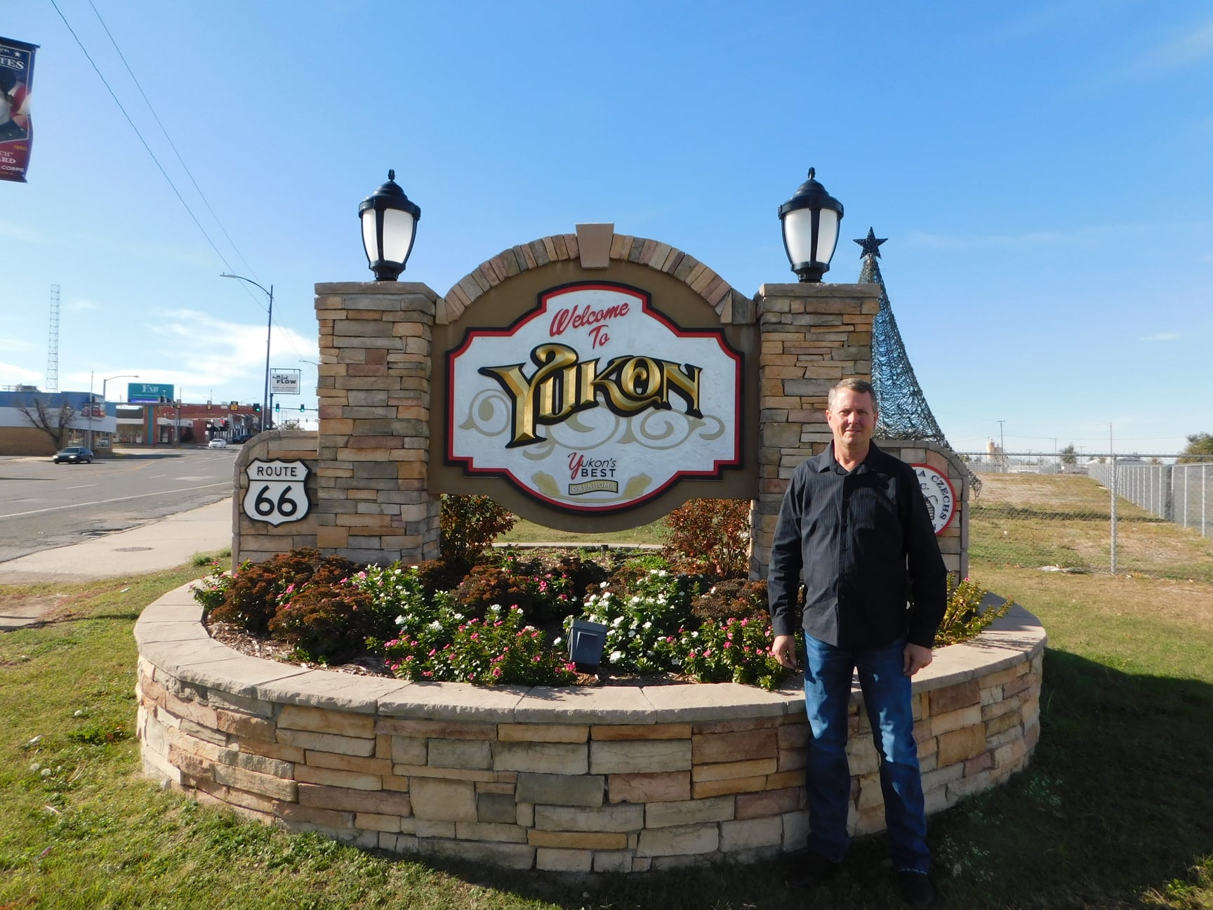 Rodney Zimmerman standing in front of the Welcome to Yukon sign on historic Route 66